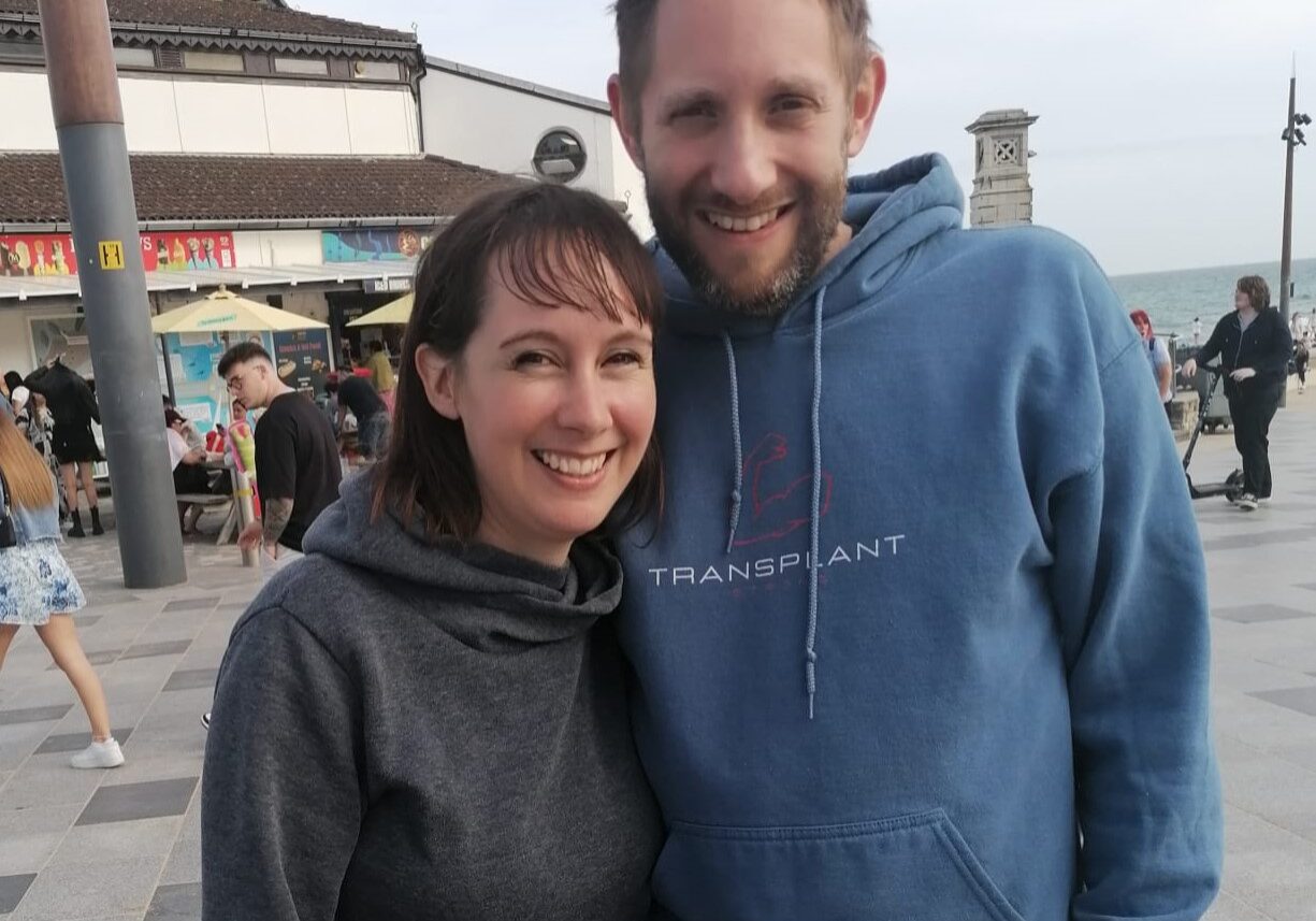 James_and_his_wife_one_year_after_transplant_outside_smiling_and_leaning_into_each_other