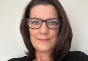 Claire with brown shoulder length hair, classes, looking directly to camera
